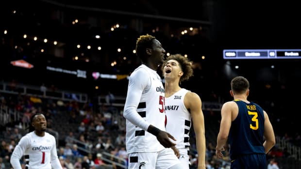 Cincinnati Bearcats forward Aziz Bandaogo (55) celebrates with Cincinnati Bearcats guard Dan Skillings Jr. (0) after drawing a foul and hitting a layup in the first half of the Big 12 Conference tournament between Cincinnati Bearcats and West Virginia Mountaineers at T-Mobile Center in Kansas City, Mo., on Tuesday, March 12, 2024.